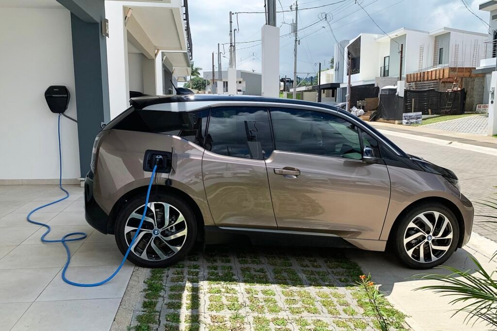Electric car charging from a wall-mounted Level 2 charger outside a home