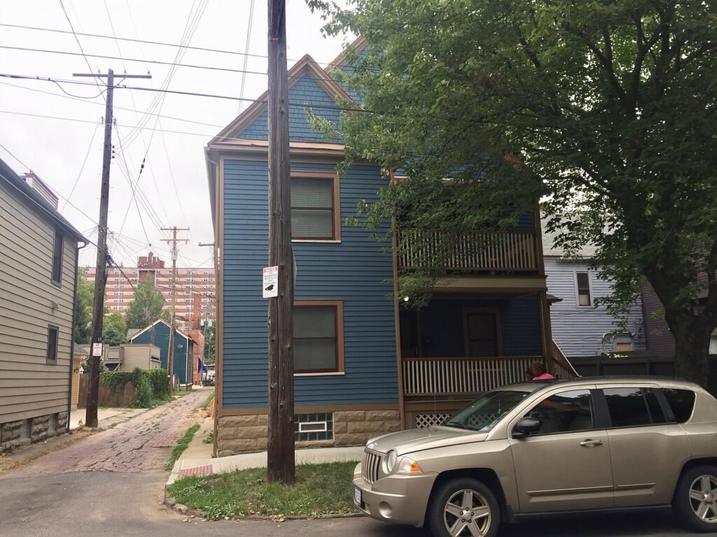 Older two-story frame house with overhead utility lines in Cleveland's Ohio City